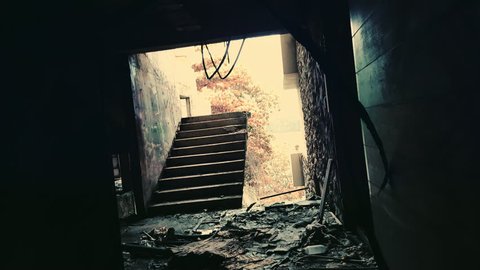 Shaky camera comes out of dark corridor and moves towards damaged staircase leading nowhere. Exploring of abandoned place full of debris. Bad dream and nightmare scene concept. First-person view.