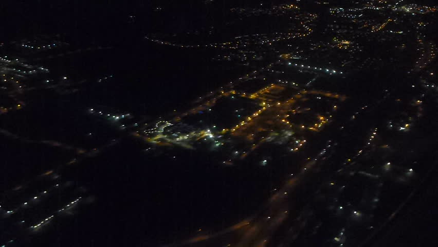 Flying in airplane over Portland, Oregon at night with landing gear lowering in