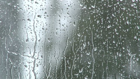 Rain falling on glass during rain storm.