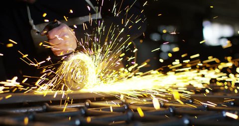 .blacksmith or welder,with its grinding smooths steel and iron,in extreme slow motion,to make the surface smooth.The grinding wheel contact with the iron causes sparks.concept:work,locksmith industry.