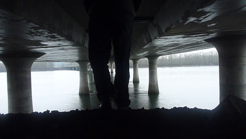 Person walks away, below large freeway bridge gapping Washington and Oregon over