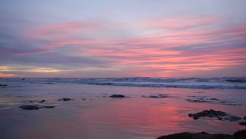 Vivid colors in clouds with waves during sunset over the Pacific Ocean.