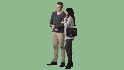 The couple is standing, discussing, looking at something. Green screen clip with alpha channel