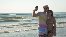Happy young couple taking a selfie on the beach