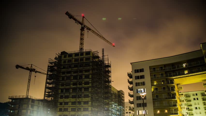 Time Lapse of building construction at night. Tower cranes and fast moving clouds Royalty-Free Stock Footage #23030356