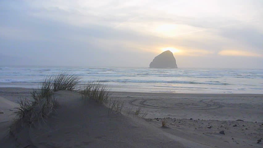 Man walking away on sandy beach to the Pacific Ocean in Oregon's coastline