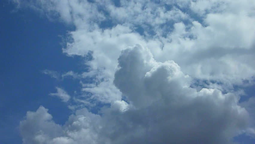 Large cumulus storm clouds build on blue sky day time lapse.