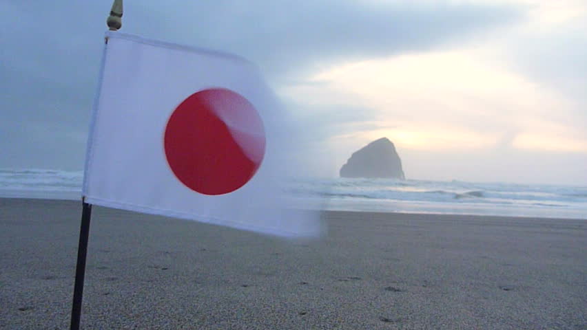 Japan flag waving at the ocean as a memorial to the earthquake victims.