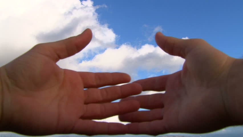 Hands covering camera lens reveal cloudscape concept.
