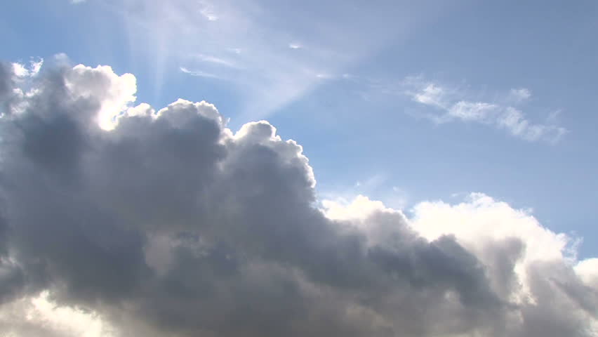 Beautiful cloudscape with large, building clouds and sunset behind shining sun rays and eventually breaking through cloud mass. Royalty-Free Stock Footage #2303555