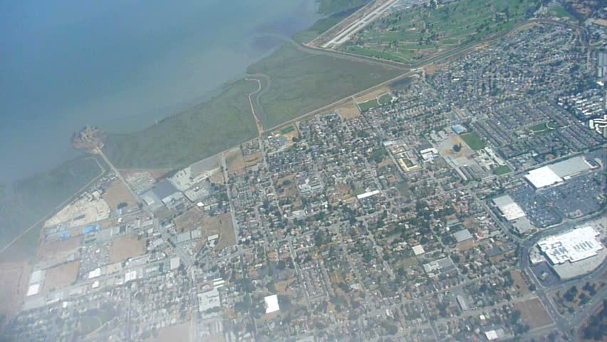 Flying in airplane over San Francisco Bay and the urban development.
