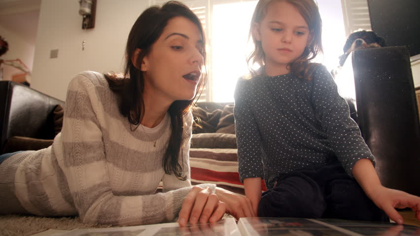 Mother And Daughter At Home Looking Through Photo Album