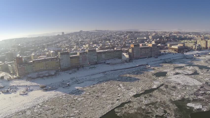 Aerial view of Tulcea city harbor and the Danube covered in ice floes
