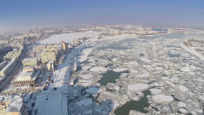 Aerial view of Tulcea city harbor and the Danube covered in ice floes
