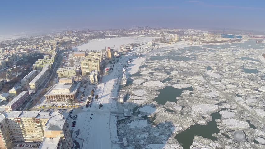 Aerial view of Tulcea city harbor and the Danube covered in ice floes
