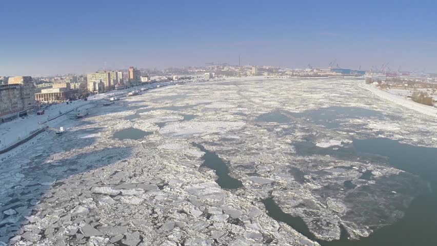 Aerial view of Tulcea city harbor and the Danube covered in ice floes
