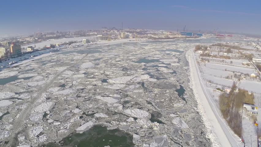 Aerial view of Tulcea city harbor and the Danube covered in ice floes
