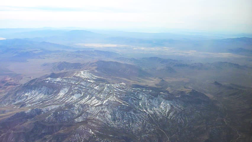 Flying in airplane over mountainous landscape over Sierra Nevada.