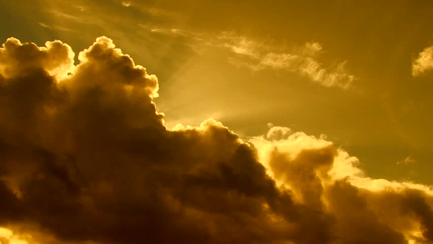 Beautiful cloudscape with large, building clouds and sunset behind shining sun