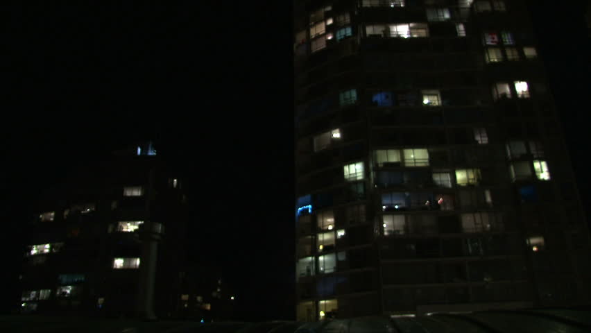City life at night in Vancouver Canada showing many people in their condominium homes turning on and off their lights with fireworks display.