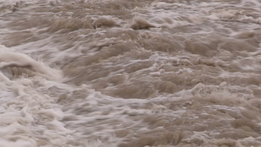 Spring river flooding and fast moving water in warm January weather

