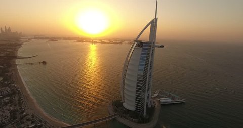DUBAI, UAE - JANUARY 4,2017:Aerial view of Burj al Arab at sunset with The Palm on the background.The Burj al-Arab is a symbol of Dubai a luxury hotel standing on an artificial island next to Jumeirah