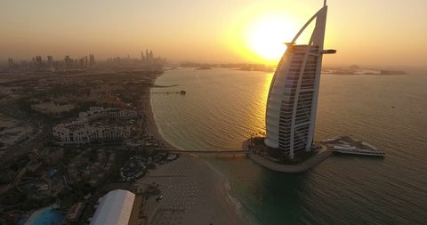 DUBAI, UAE - JANUARY 4,2017:Aerial view of Burj al Arab at sunset with The Palm on the background.The Burj al-Arab is a symbol of Dubai a luxury hotel standing on an artificial island next to Jumeirah