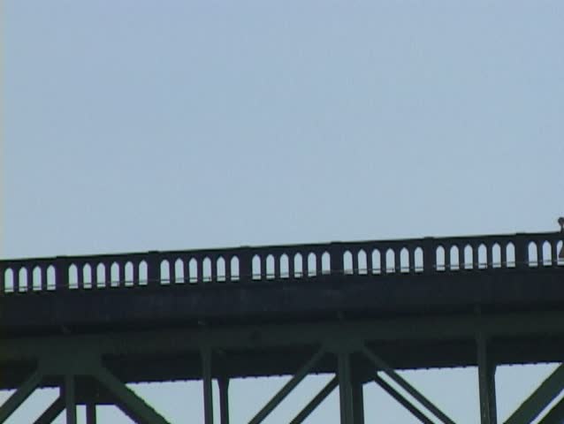 Person running across bridge with traffic.