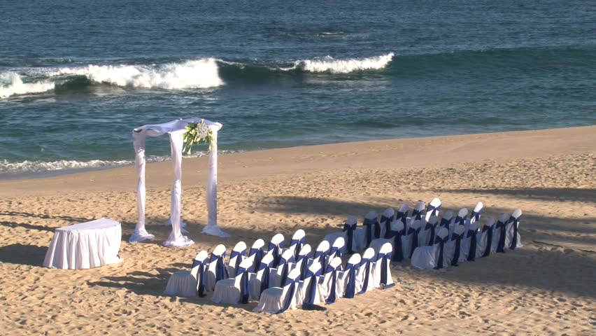 Ocean front wedding ceremony on sandy beach.