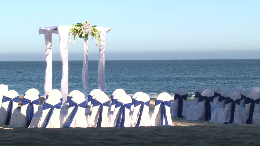 Ocean front wedding ceremony on sandy beach.