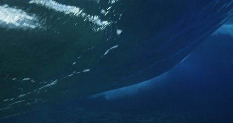 Underwater view of surfer riding ocean wave