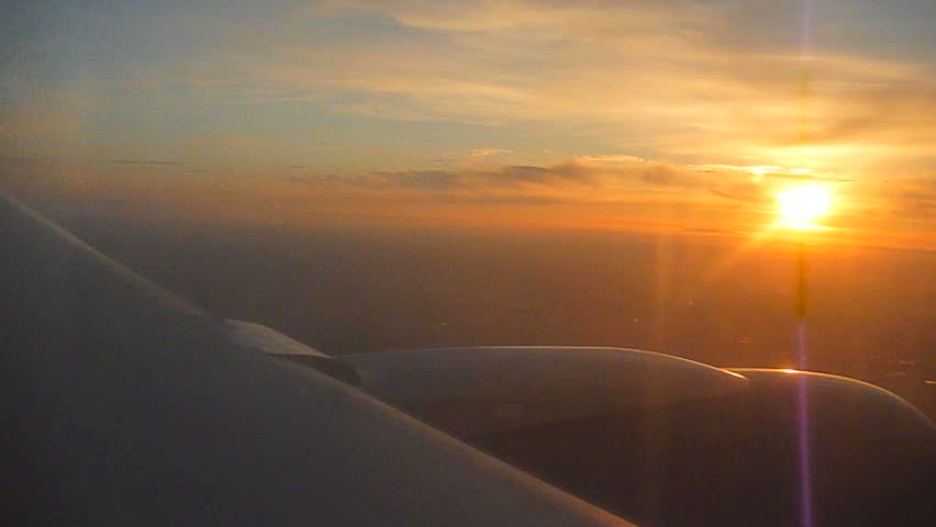 Flying in airplane during sunset.