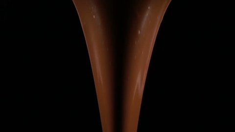 stream of melted chocolate pouring on a black background