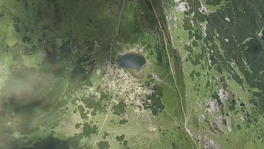 Lake in the hills, gorgeous mountain terrain shot from the height of bird flight