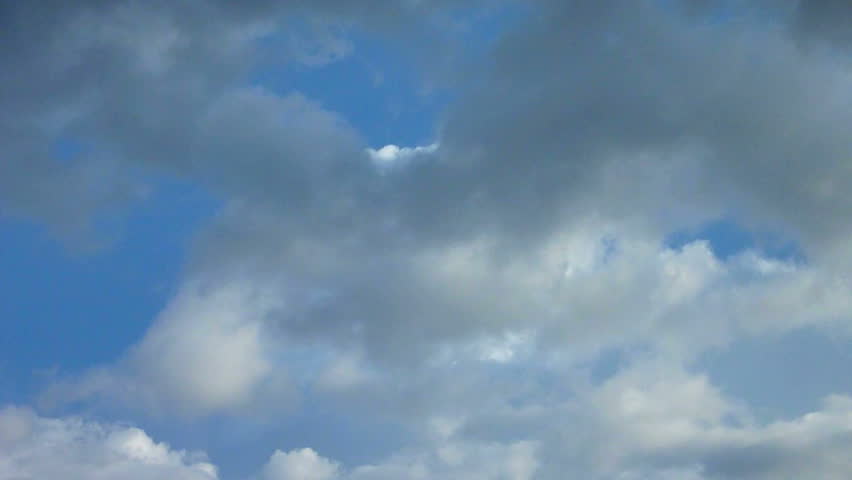 Clouds slowly move in multiple layers on blue sky day, turning to storm time