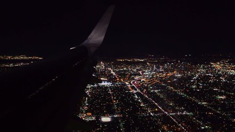 Aerial view from airplane window over Los Angeles City Lights on approach to landing at airport