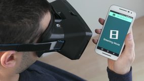 Man shopping online wearing a VR headset and his smartphone. Virtual reality applications.