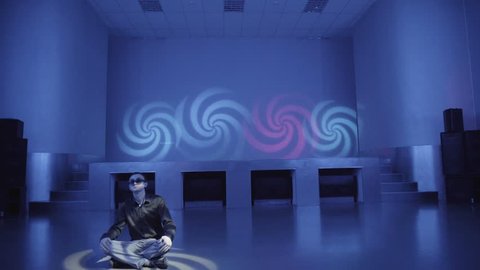 Hypnotized man in sunglasses sitting in Lotus posture