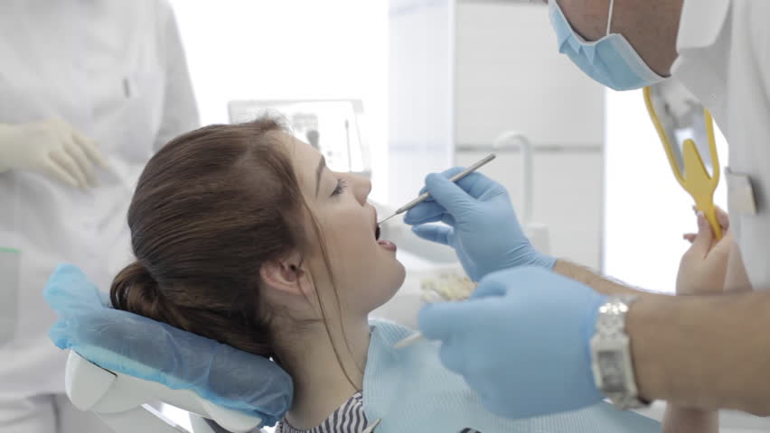 Close up portrait of young women in dentist chair. Doctorheck and select the color of the teeth. | Shutterstock HD Video #23092348