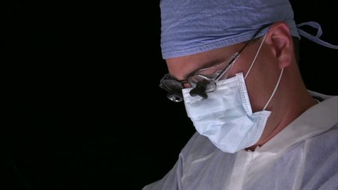 Surgeon working with specialized glasses on.  Thumbs up and smile for success at the end.  HD 1080i