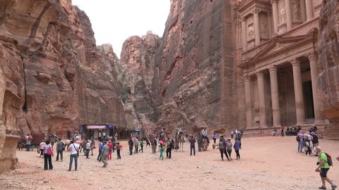 PETRA, JORDAN - NOVEMBER 2016: Crowds of tourists take photos and visit the popular Treasury, one of the most iconic buildings of ancient Petra in Jordan