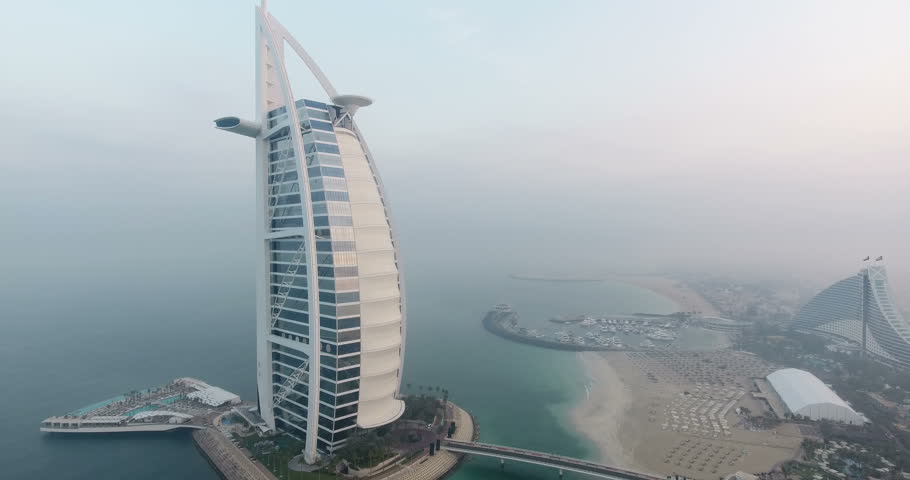 DUBAI, UAE - JANUARY 4, 2017:Aerial view of Burj al Arab hotel at sunrise.The Burj al-Arab is a symbol of Dubai and a luxury hotel standing on an artificial island next to Jumeirah beach.foggy weather