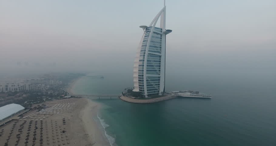 DUBAI, UAE - JANUARY 4, 2017:Aerial view of Burj al Arab hotel at sunrise.The Burj al-Arab is a symbol of Dubai and a luxury hotel standing on an artificial island next to Jumeirah beach.foggy weather
