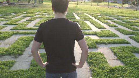 Camera fly from Above teen-age  boy looking around a life-size Labyrinth Maze
It shows thoughtfulness before choosing the life path

Released