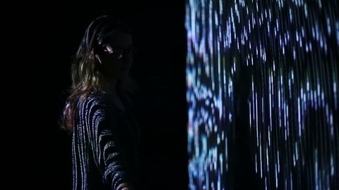 ABRAU-DURSO, RUSSIA - September 11, 2016: Girl play with interactive video installation. A new kind of art, generative graphics. Audio-visual exhibition in MARS Center, ABRAU-DURSO