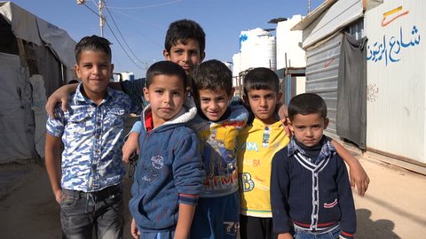 ZAATARI REFUGEE CAMP, JORDAN - NOVEMBER 2016: Syrian refugee kids pose for the camera inside the Zaatari camp in Jordan