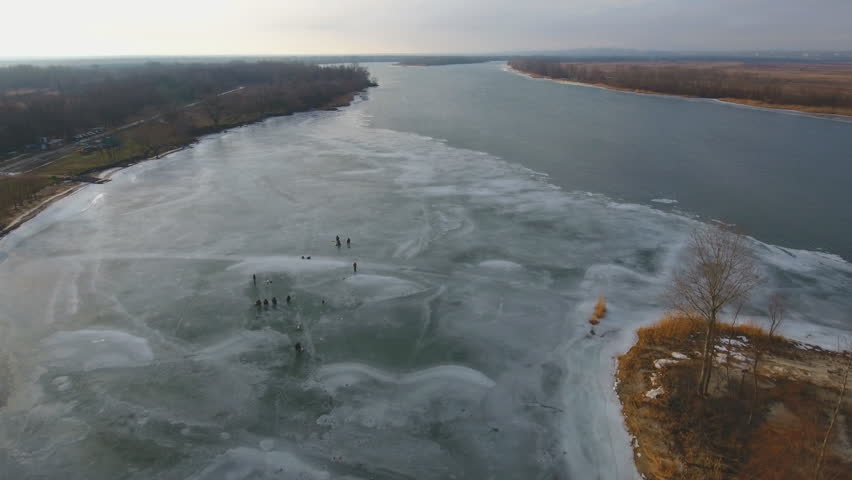 Winter fishing on the river. Fishermen on the ice floes.  circular aerial view