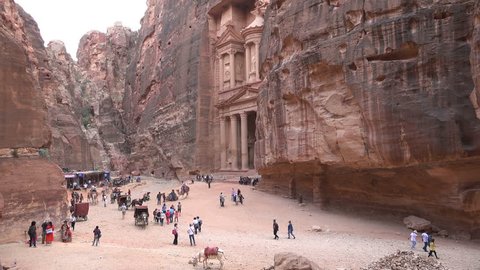 PETRA, JORDAN - NOVEMBER 2016: Crowds of tourists take photos and visit the popular Treasury, one of the most iconic buildings of ancient Petra in Jordan
