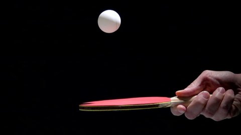 Hand holding table tennis racket and bouncing ping pong ball. Slow motion film clip with sport equipment.