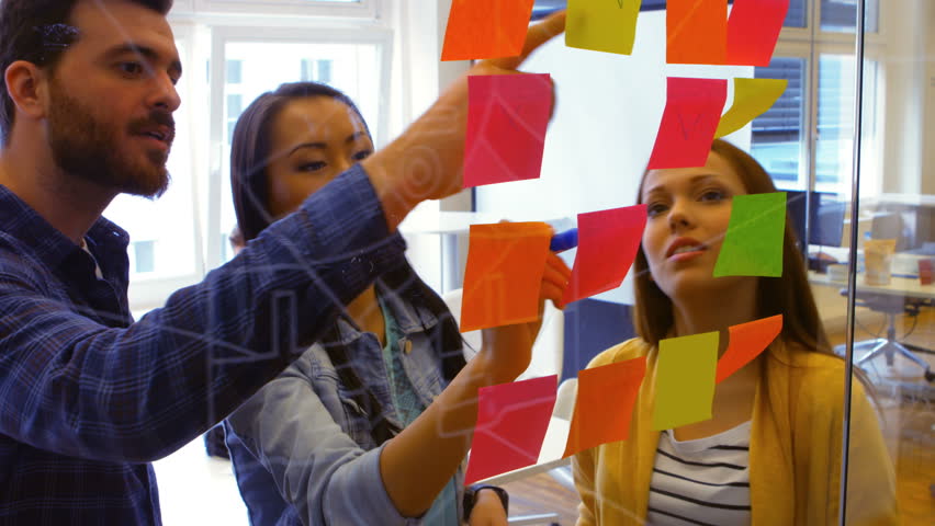 Graphic designers discussing over sticky notes in office Royalty-Free Stock Footage #23120095